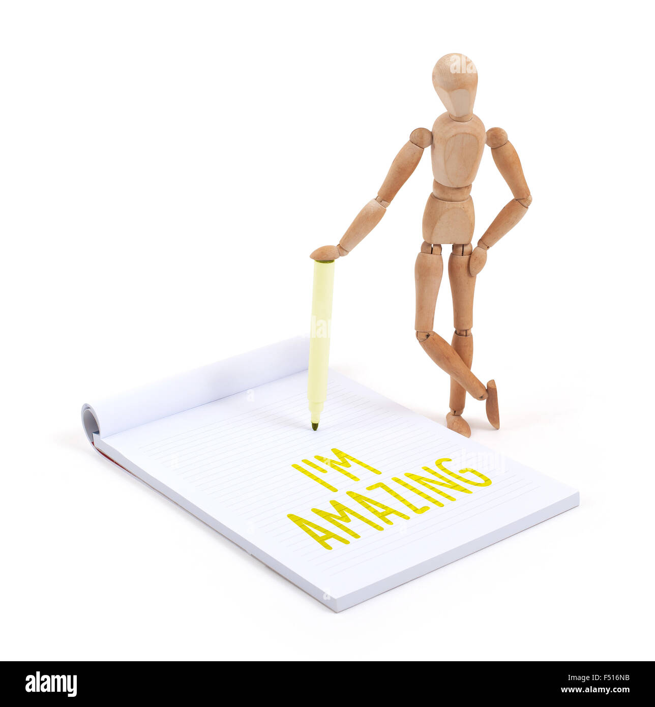 Wooden mannequin writing in a scrapbook - I'm amazing Stock Photo