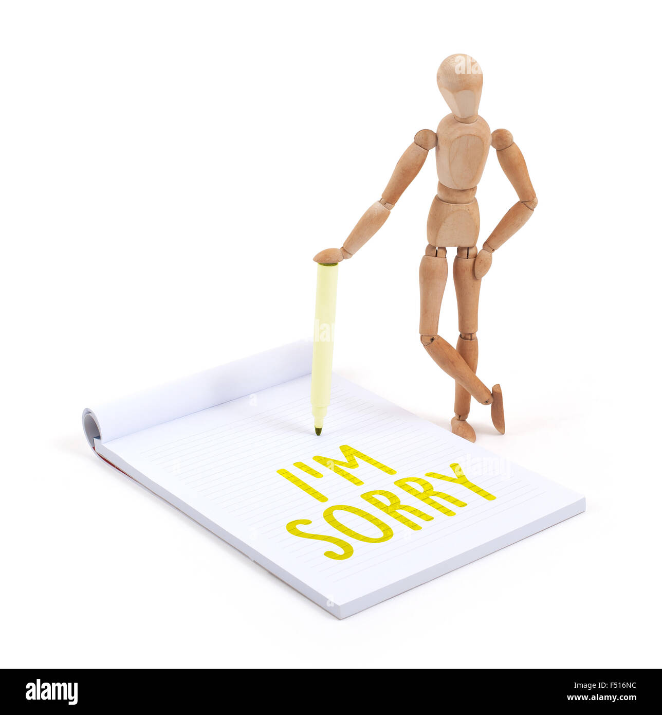 Wooden mannequin writing in a scrapbook - I'm sorry Stock Photo