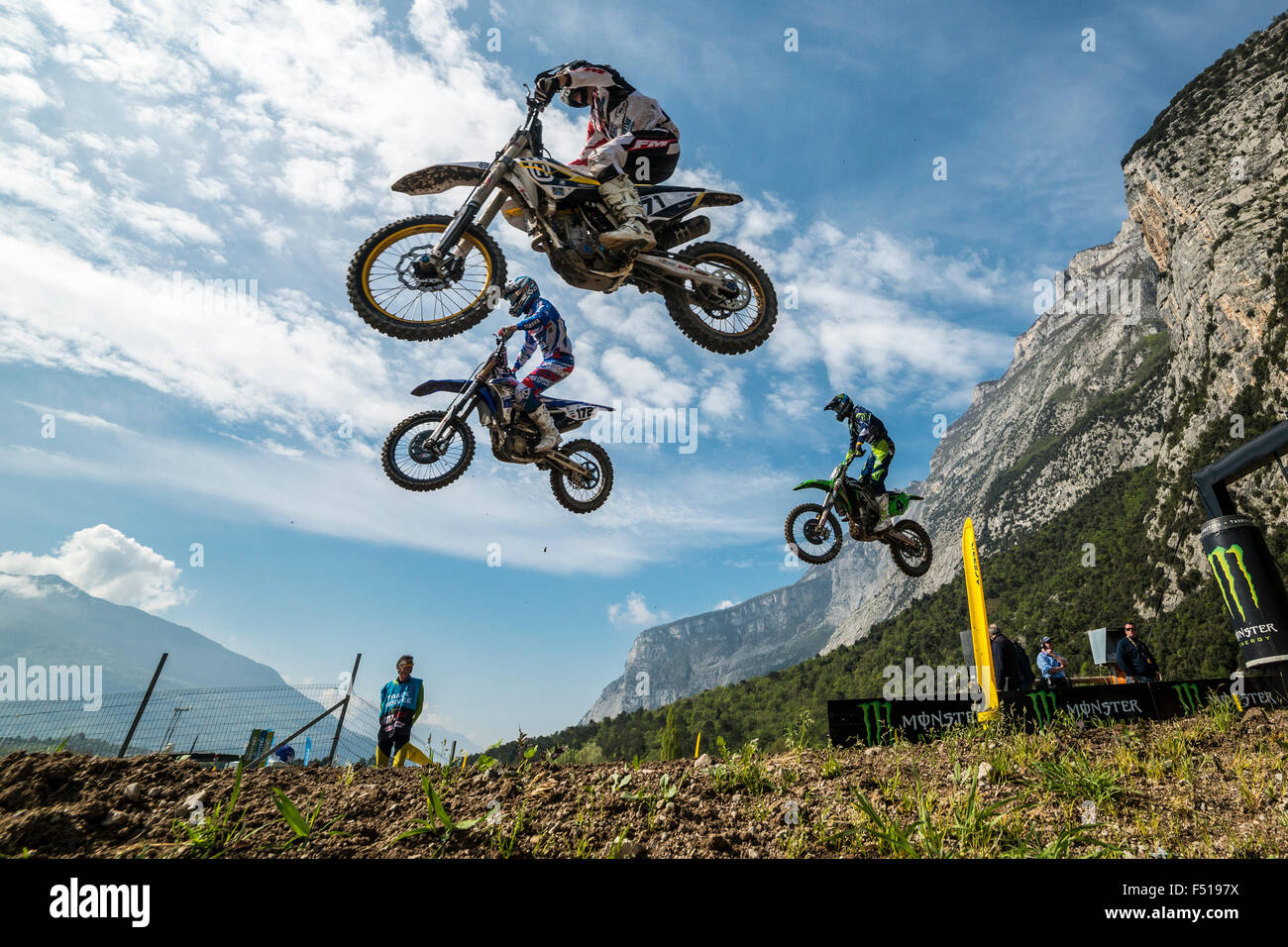 Three motorcyclists on motocross bikes are jumping through the air