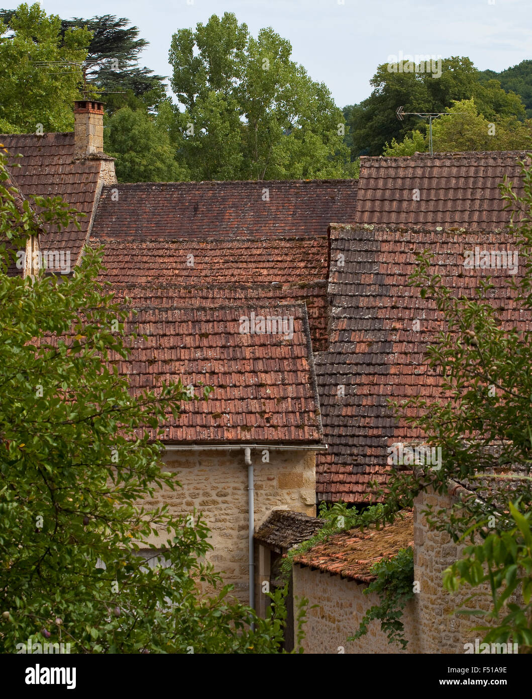 A small village in France has its buildings cluttered and crushed together. The image shows a detail of the village roofs in amo Stock Photo