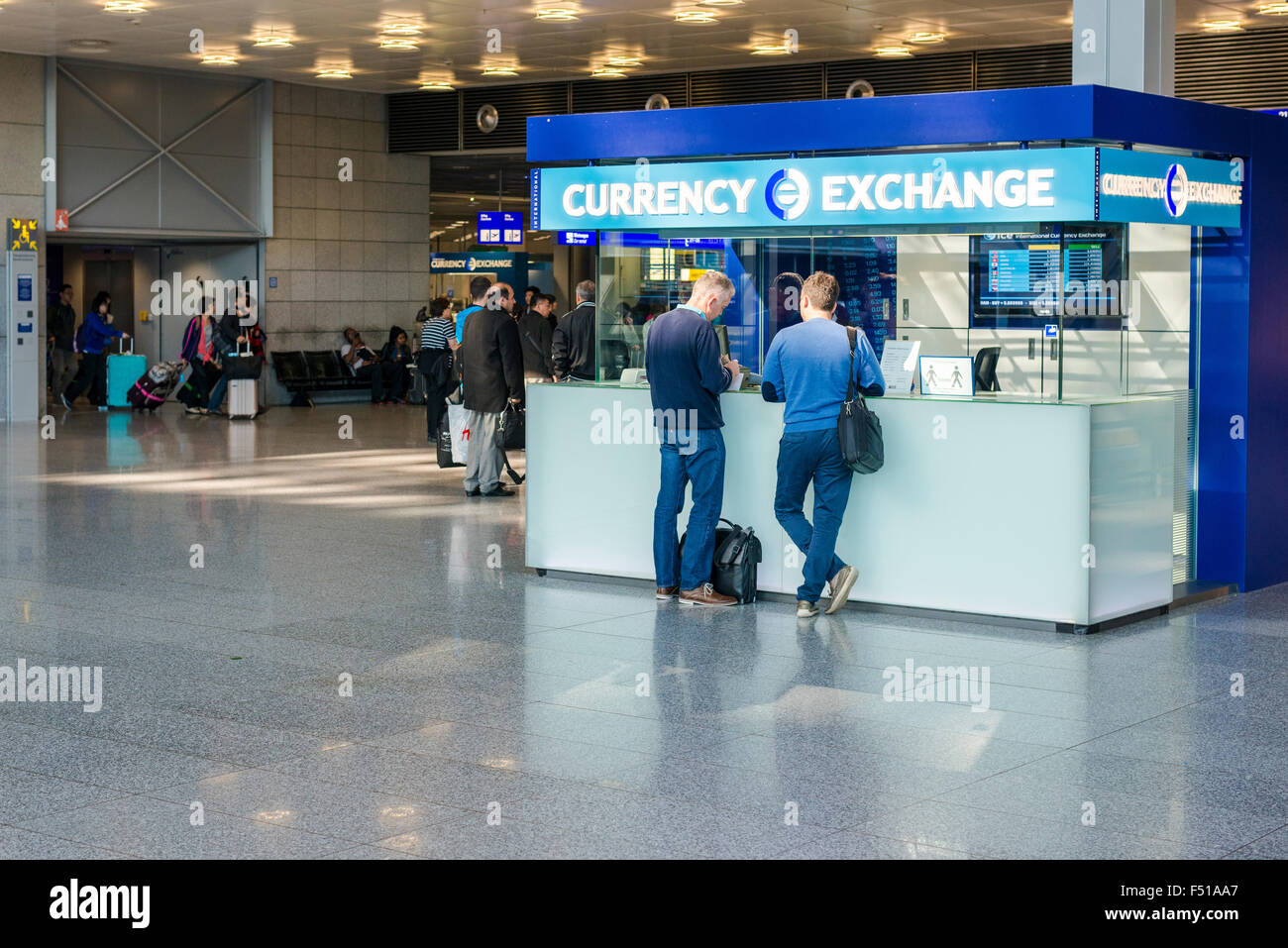 Two men are changing money at a currency exchange boot at Terminal 1 of Frankfurt International Airport Stock Photo