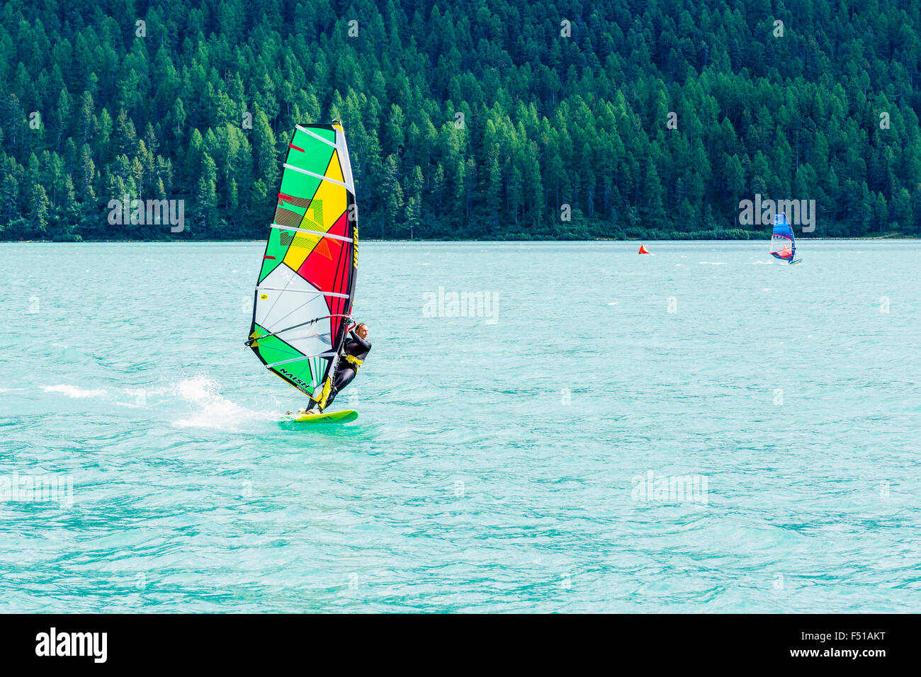 A Surfer is crossing the Lej da Silvaplana, a high altitude lake near St. Moritz Stock Photo