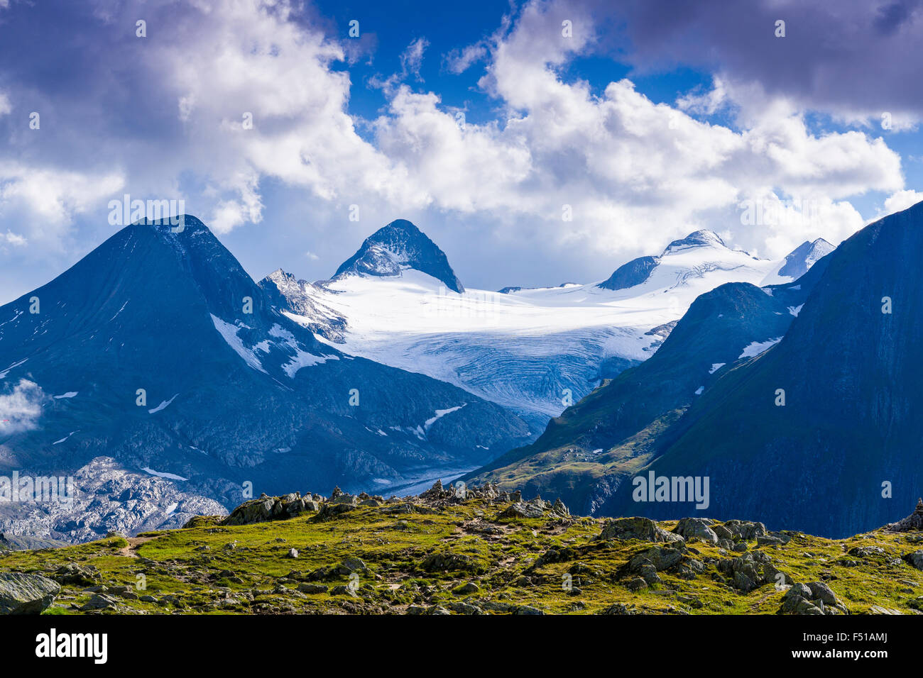The mountains Bettelmatthorn and Rothorn with a big glacier are located near Nufenenpass, dark clouds at the sky Stock Photo