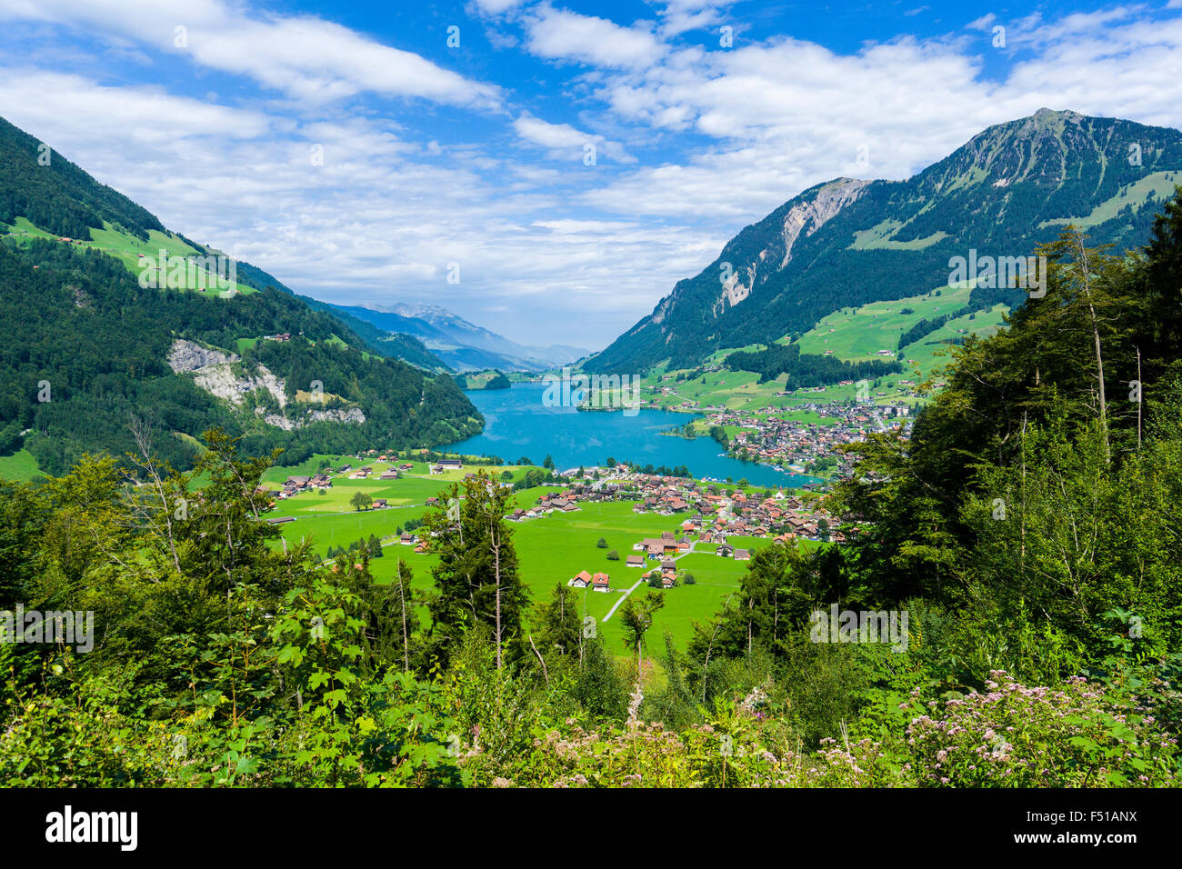 High altitude landscape with the Lake Lungern, a village, mountains and green meadows at the bottom of Brünig Pass Stock Photo