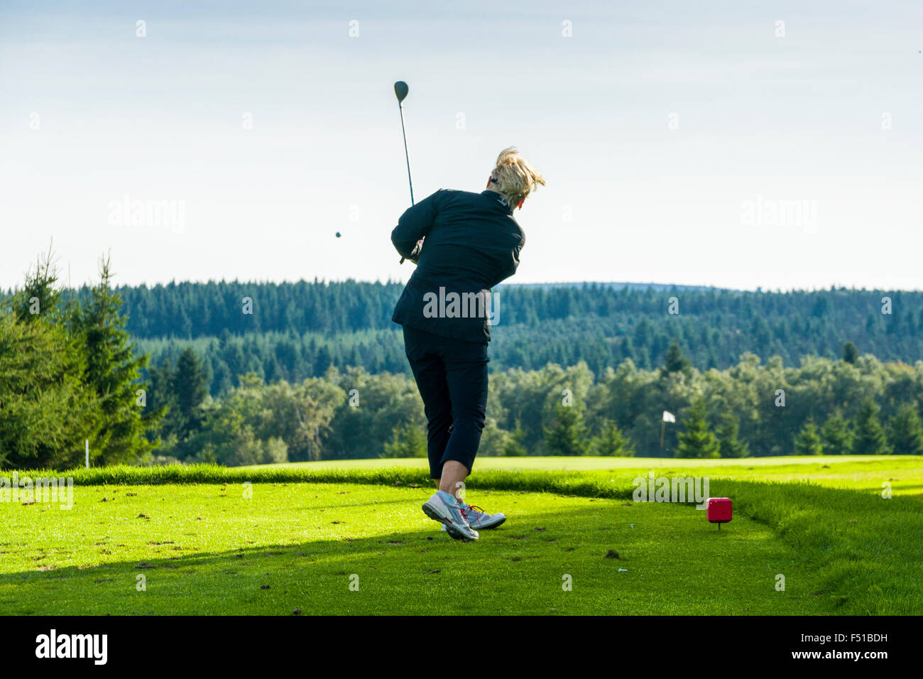 A woman is playing golf on a green meadow Stock Photo