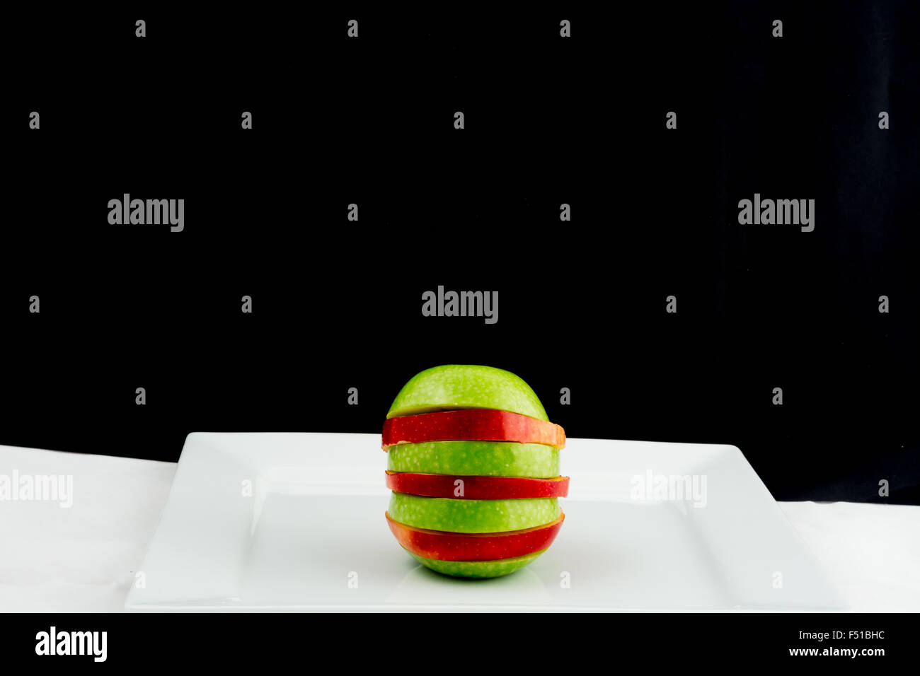 Red and green apple cut into slices Stock Photo
