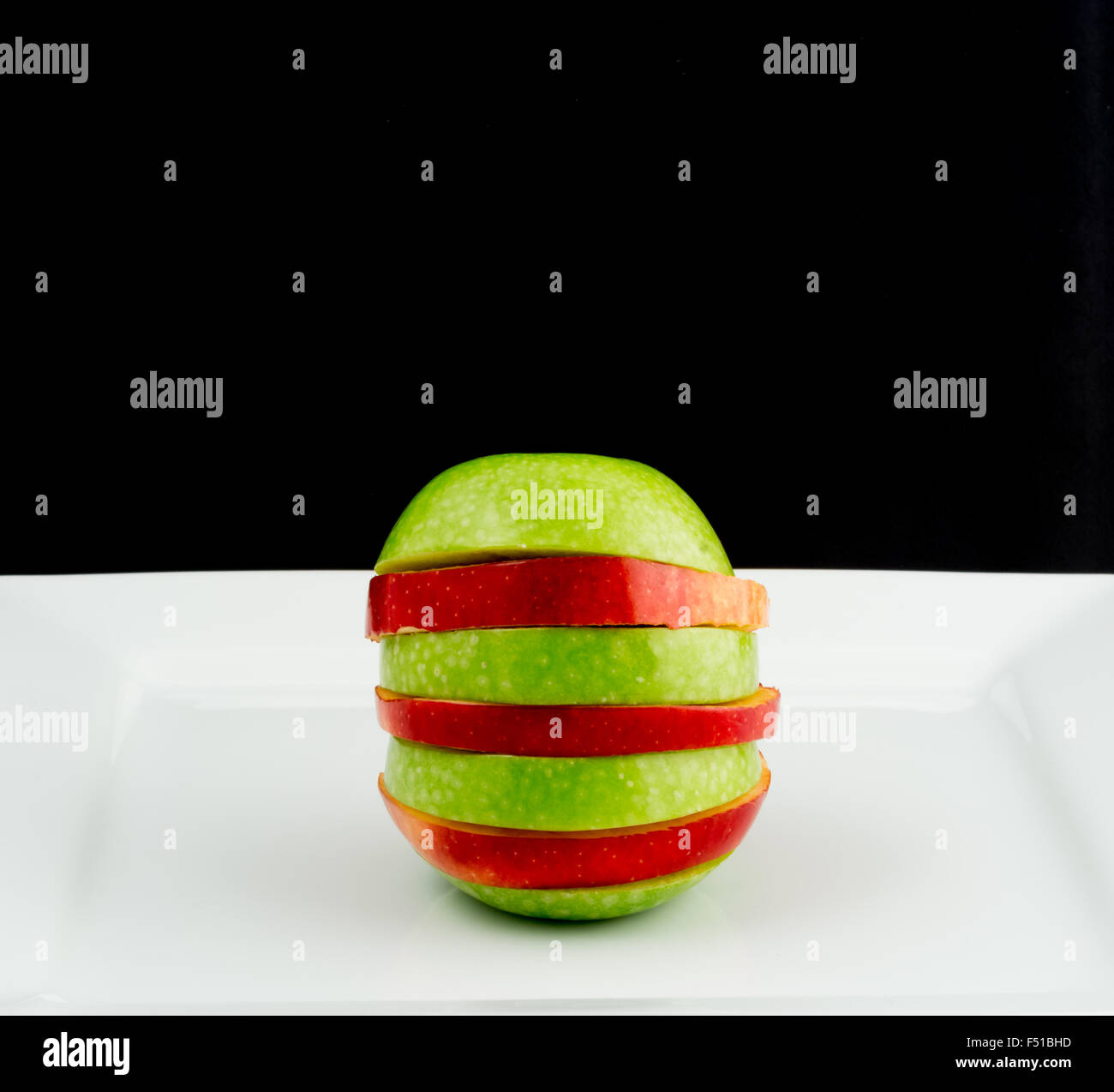 Red and green apple cut into slices Stock Photo
