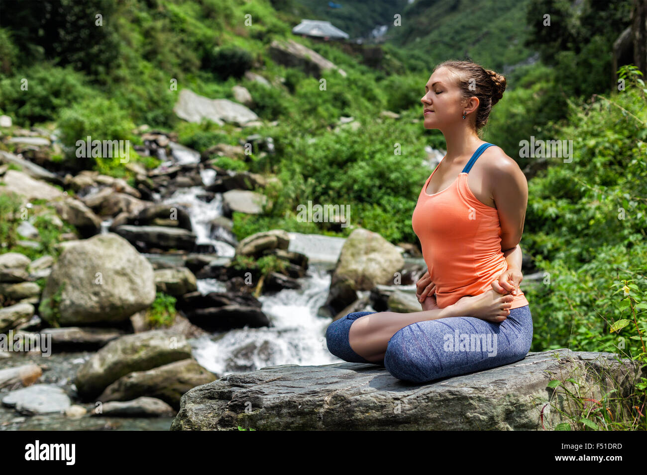 Young fit woman doing yoga oudoors at waterfall Stock Photo - Alamy