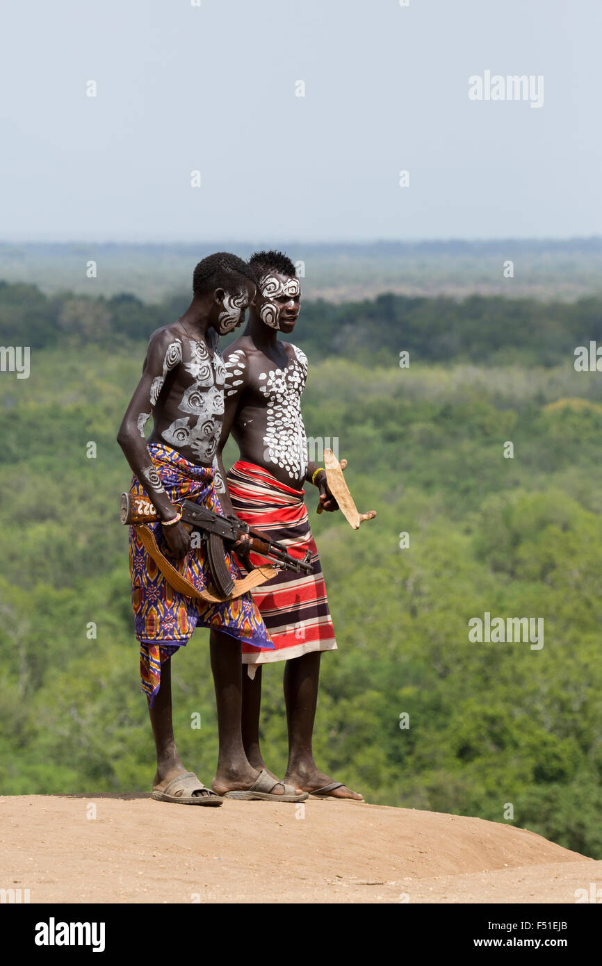 Young male Karo tribe boys with AK-47 rifle . Omo Valley, Ethiopia Stock Photo