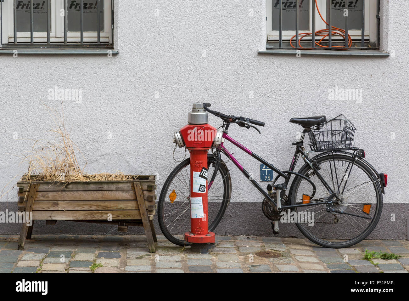Bicycle parked against a red fire hydrant in a side street of Nuremberg, Germany. Stock Photo