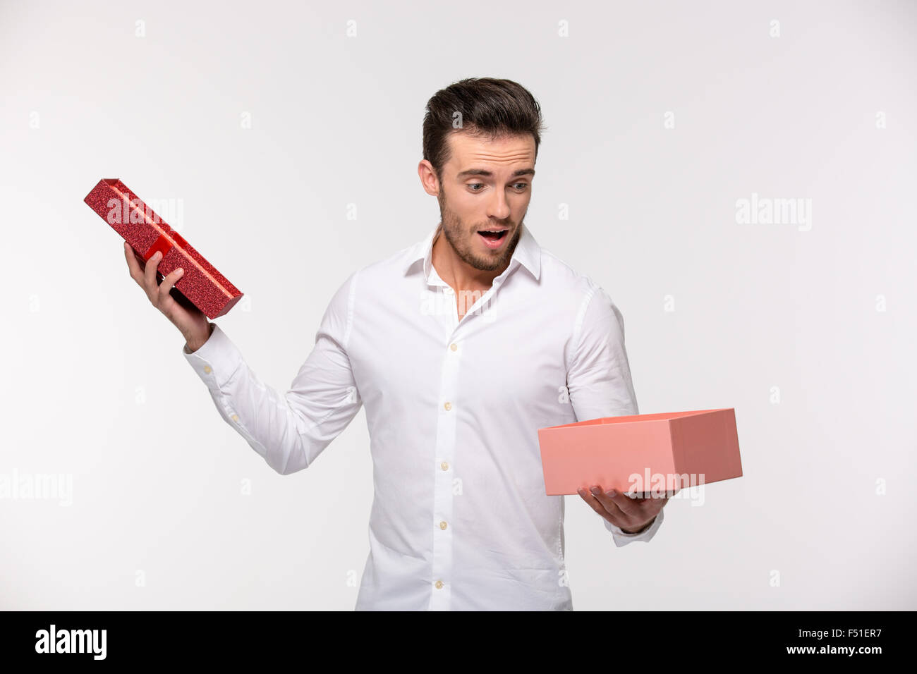 Portrait of a businessman opening gift box isolated on a white ...