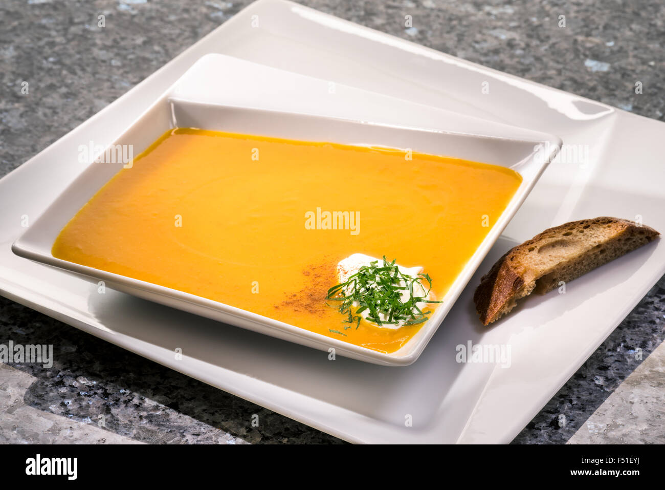 pumpkin soup meal plate soupplate soupspoon yellow orange green silver white liquid halloween fresh main starter add join enclos Stock Photo