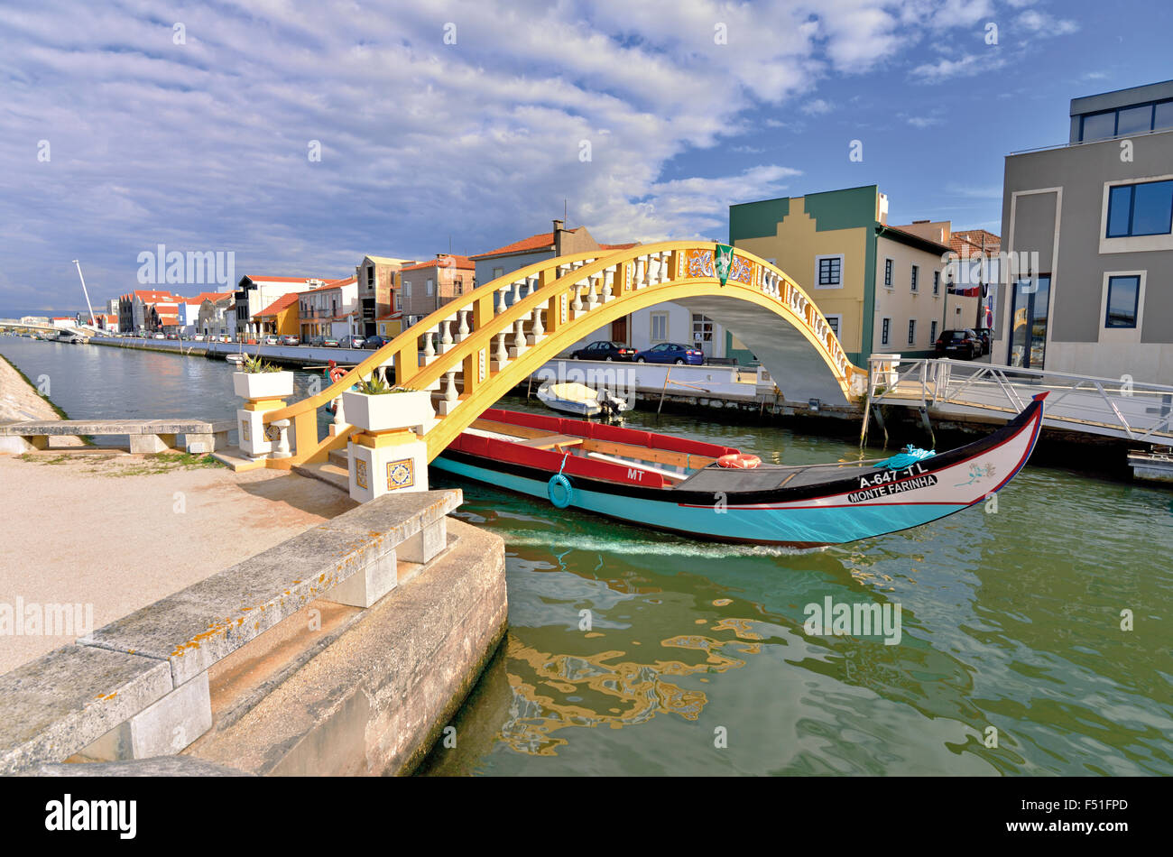 Portugal: Traditional Moliceiro boat passing bridge Ponte de Carcavelos over Sao Roque channel in Aveiro Stock Photo