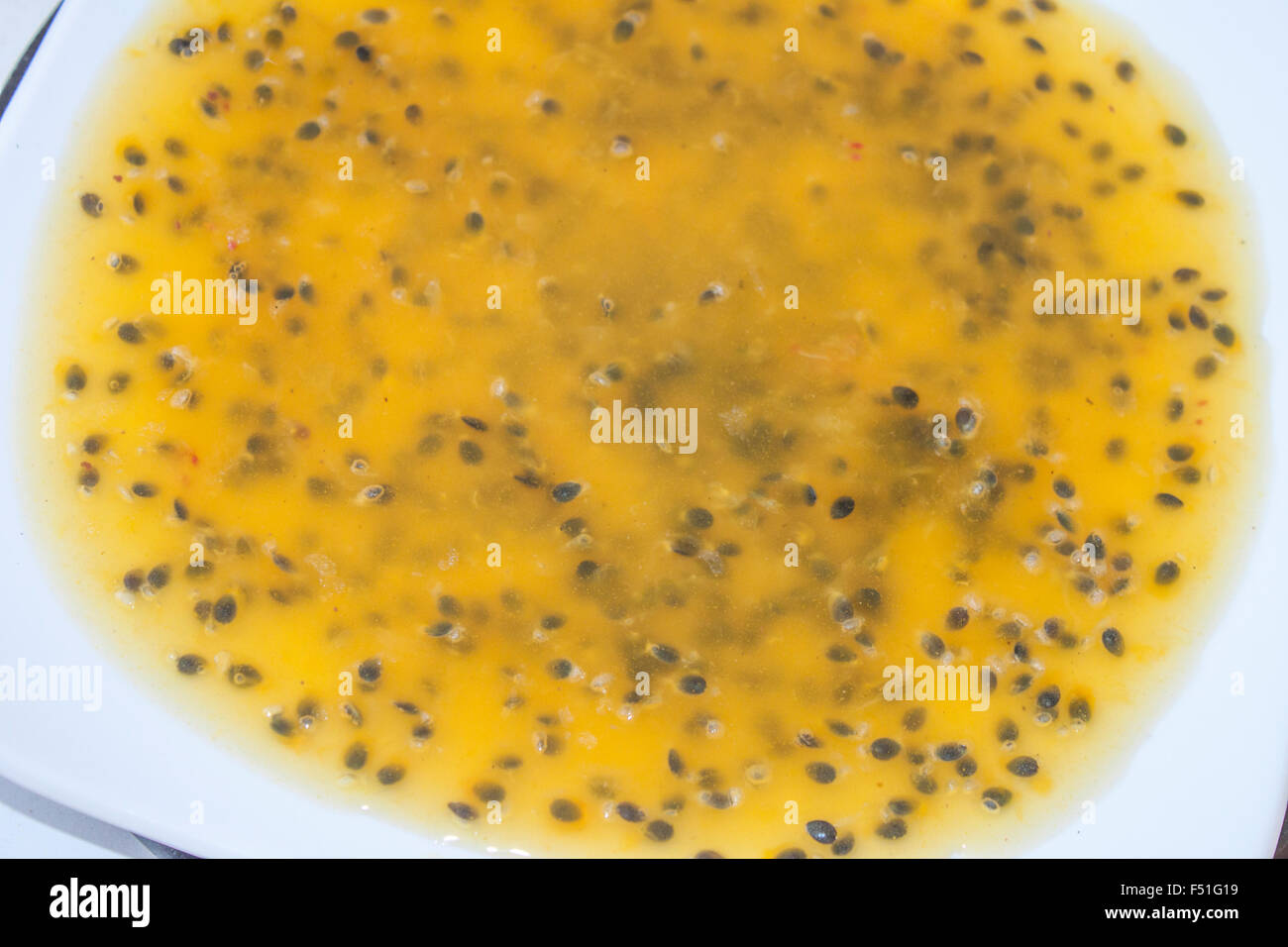 Tasty yellow passion sauce, on a white plate Stock Photo