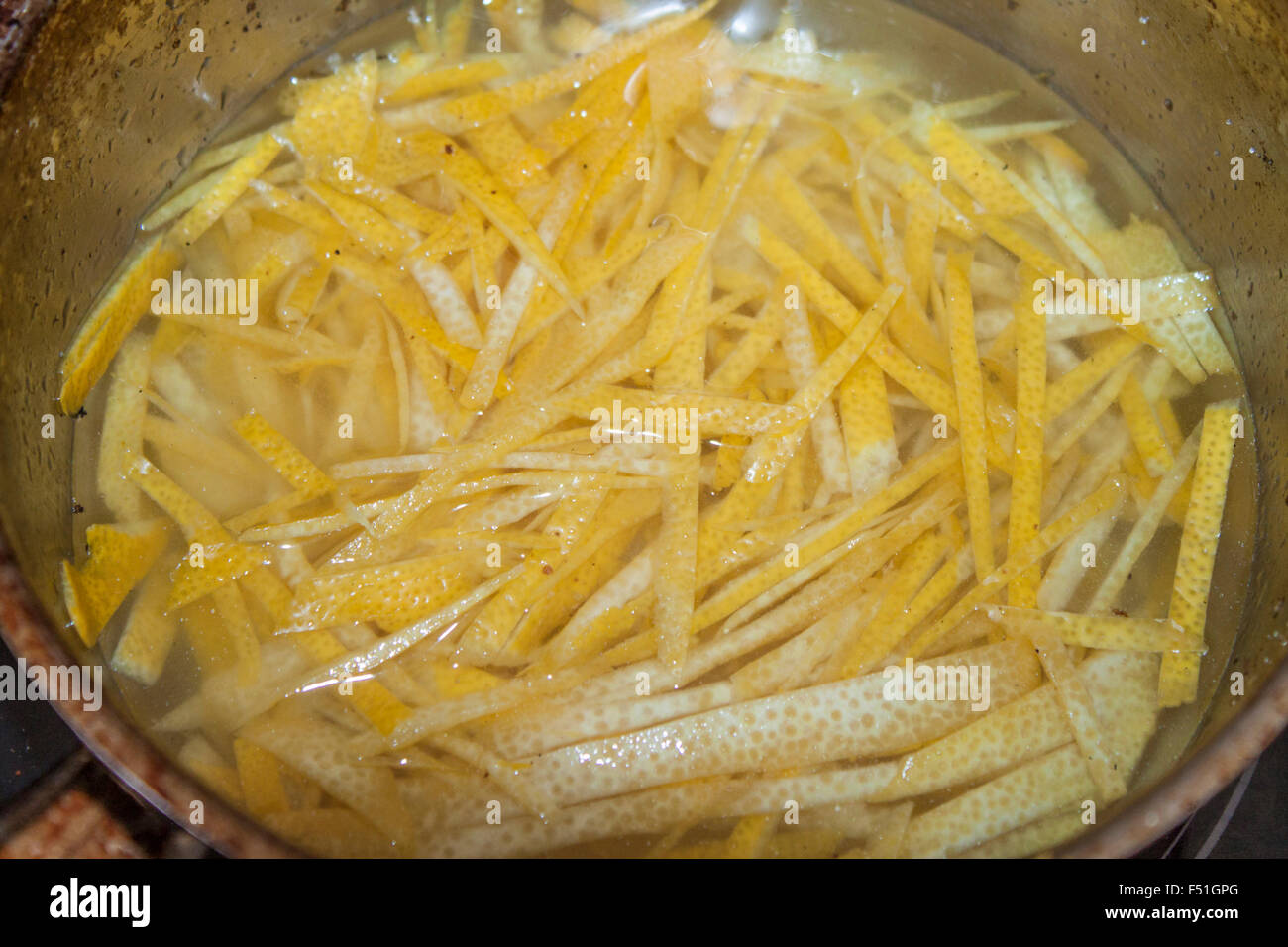 Candying lemon peel, in a pot full of syrup Stock Photo