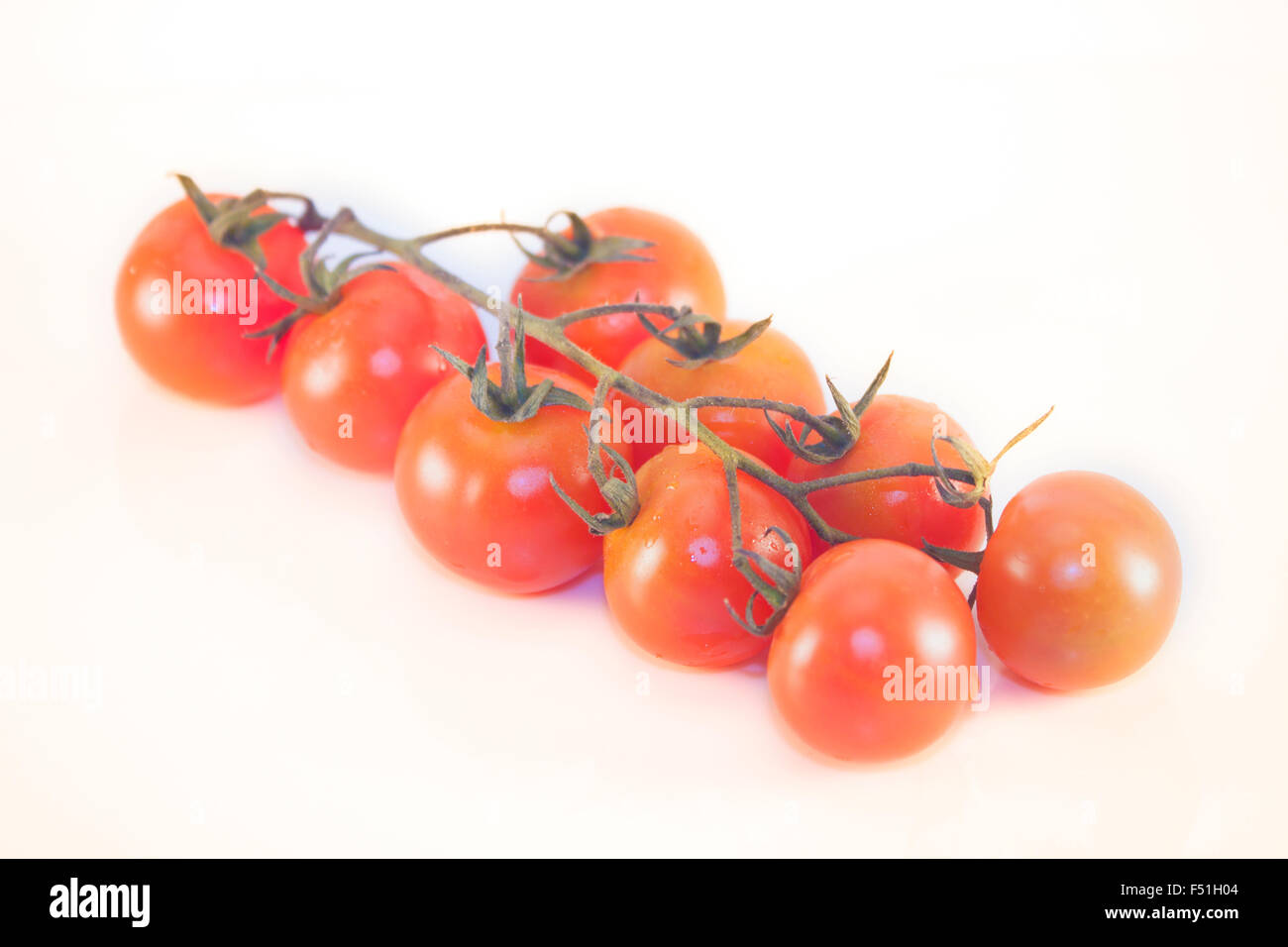 Small, red tomato cluster, isolated on white background Stock Photo