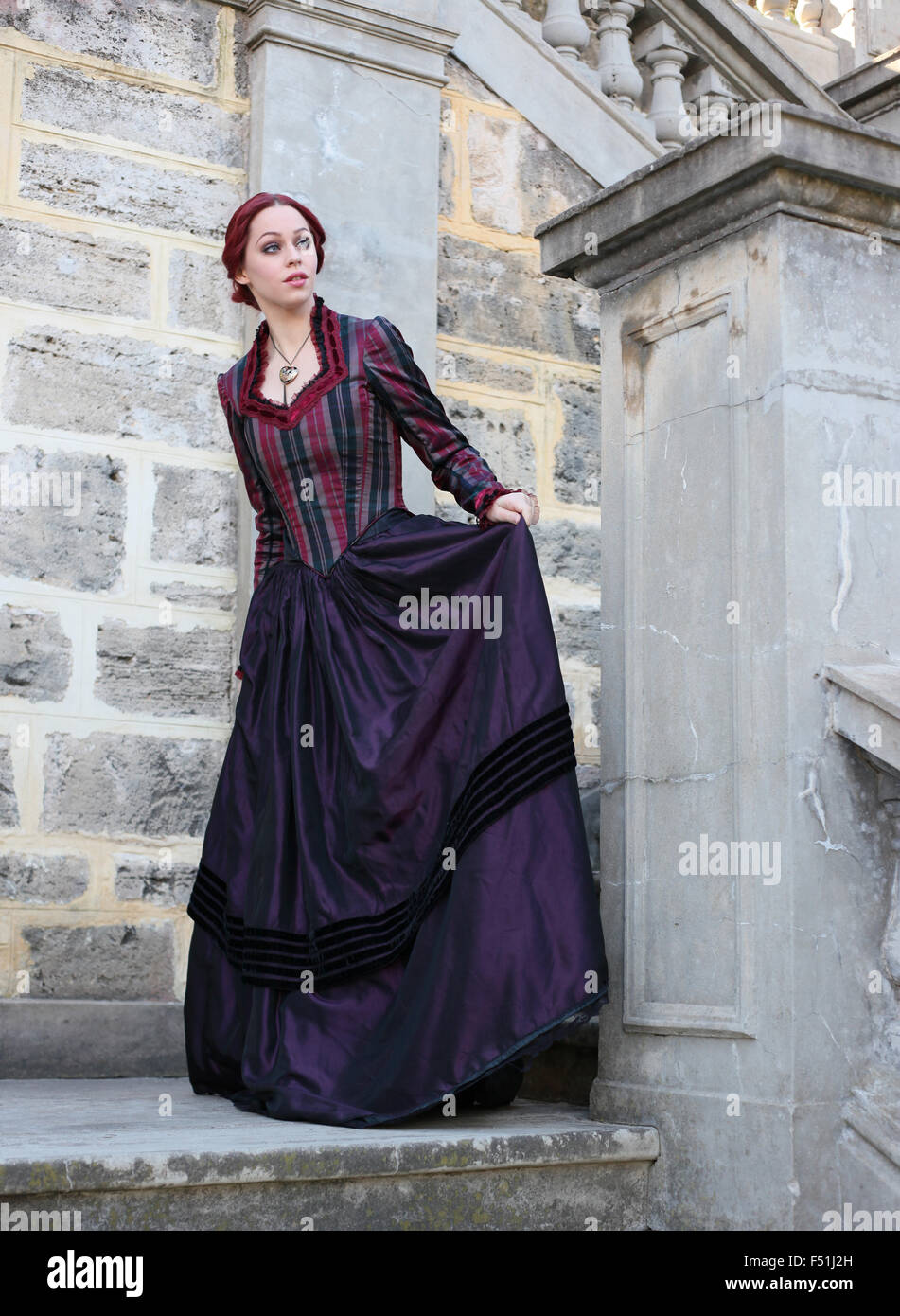 portrait of a beautiful red haired girl wearing Gothic inspired Victorian era clothes. vampire or historical romance era. Stock Photo