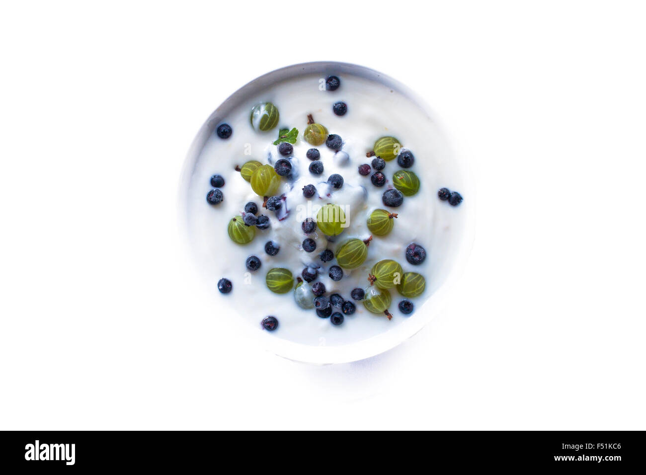 Gooseberries ribes uva-crispa, blueberries vaccinium myrtillus and yogurt, isolated on white background Stock Photo