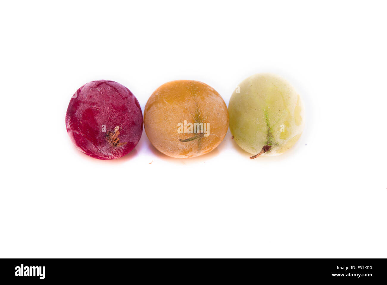 Frozen, red, green and yellow gooseberries, ribes uva-crispa, isolated on white background Stock Photo
