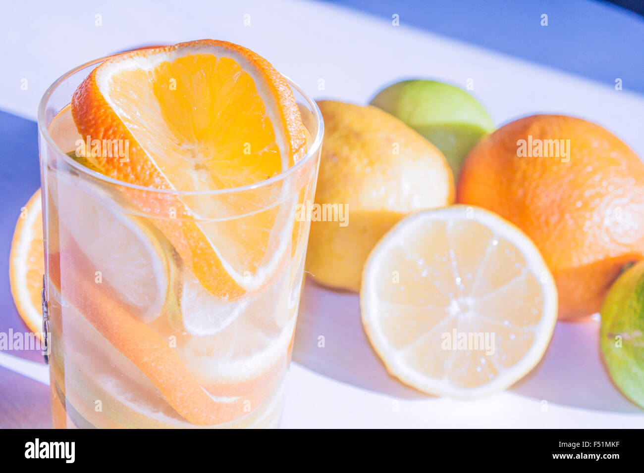 Citrus fruit drink, in front of lime, lemon and orange Stock Photo