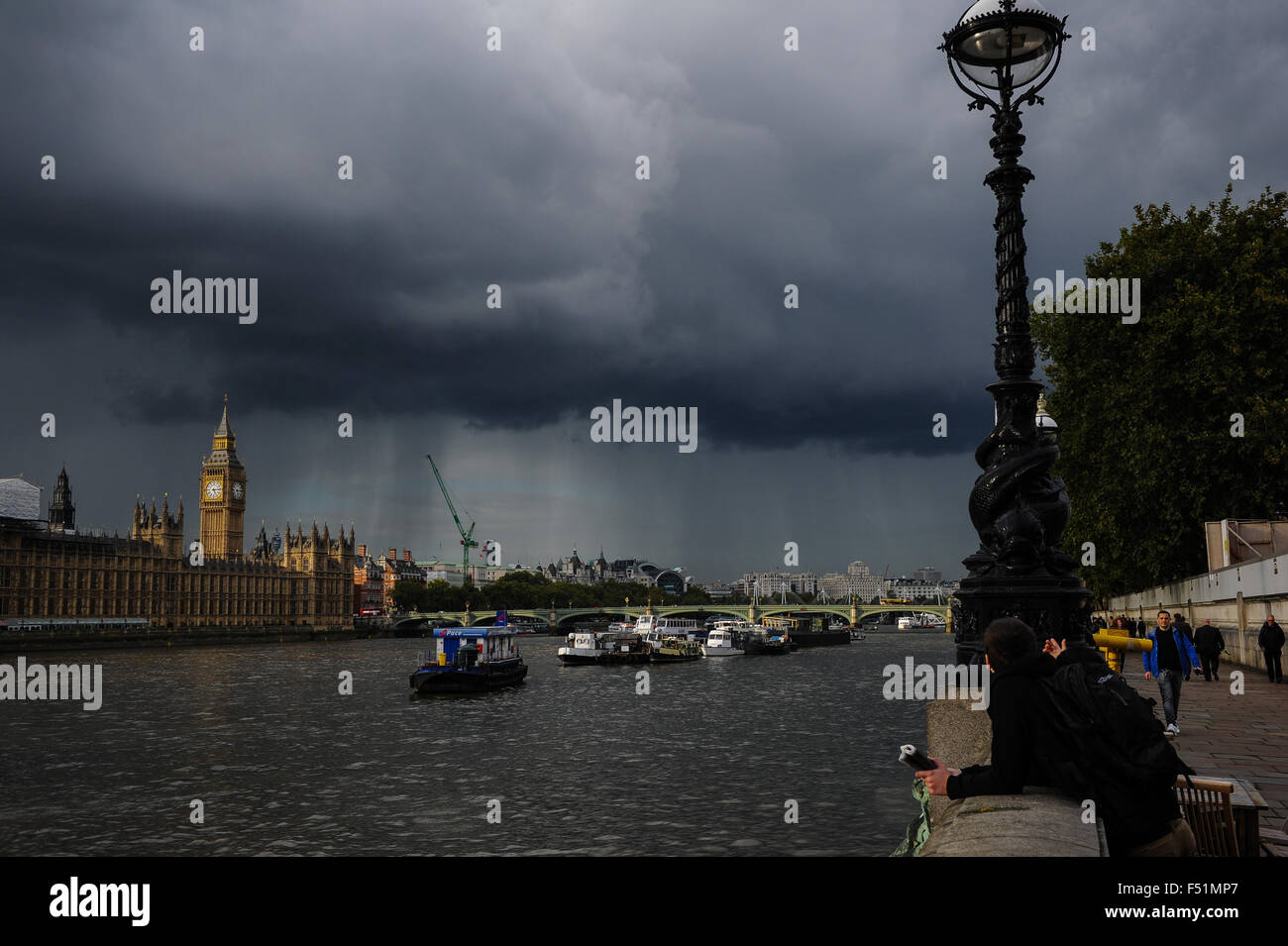 A view of House of Commons and the Thames as a dark cloud approaches with rain falling Stock Photo