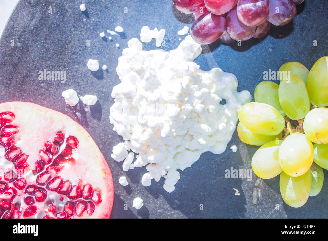 White cottage cheese, near pomegranate and grapes Stock Photo - Alamy