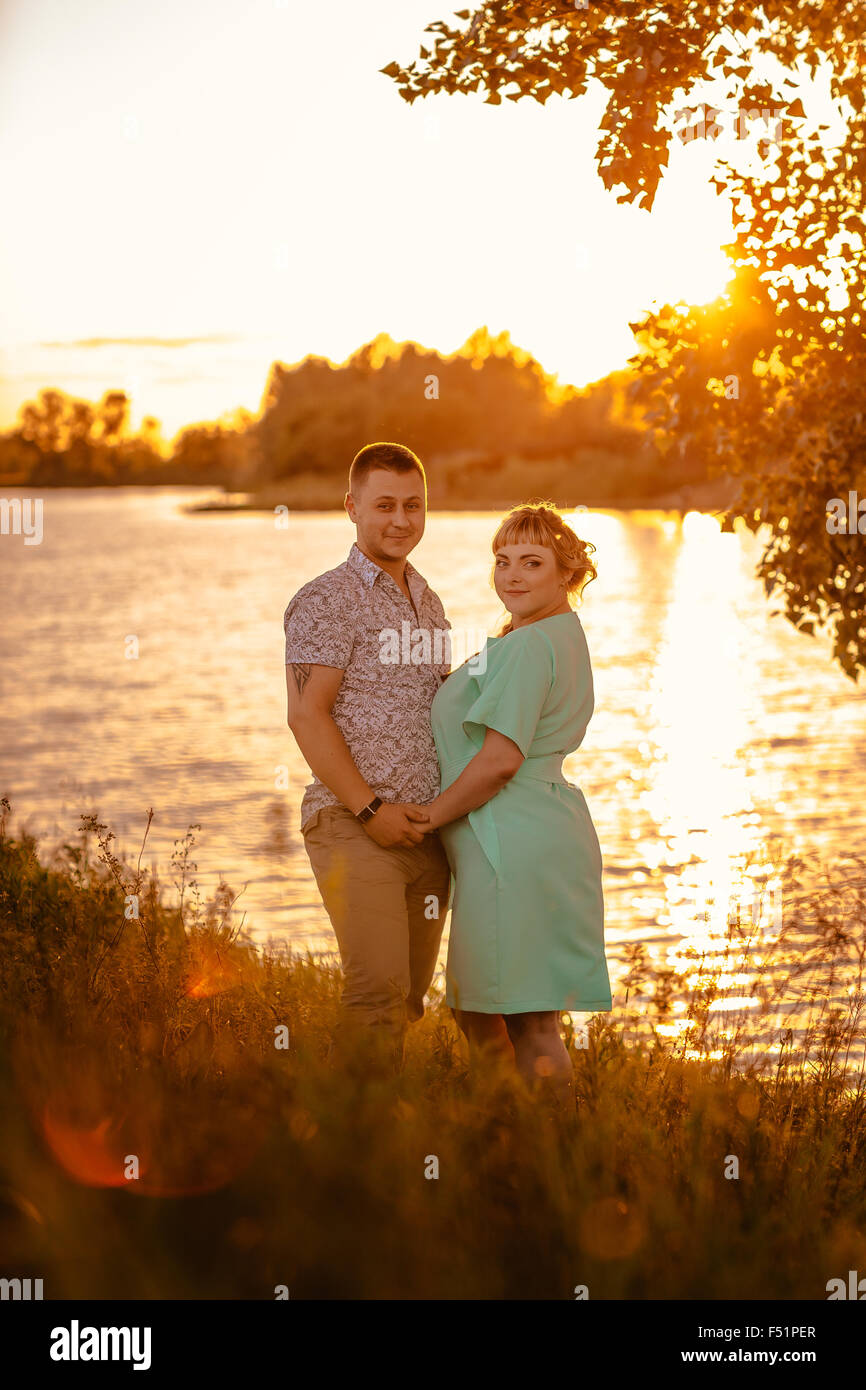 Romantic couple standing and kissing on background summer lake sunset ...