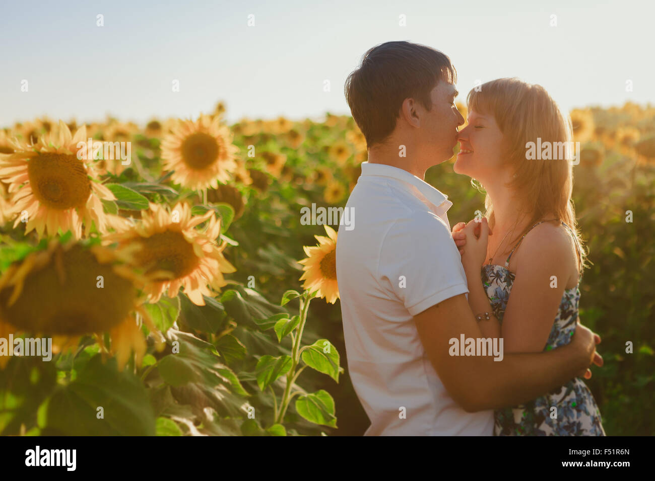 Romantic couple standing and kissing on background summer meadow ...