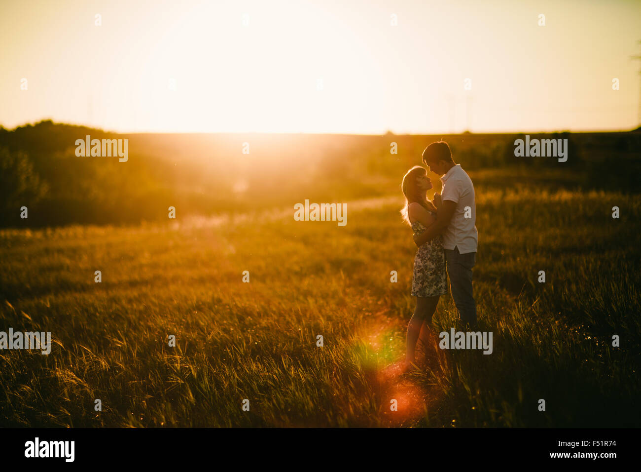 Romantic couple standing and kissing on background summer meadow ...