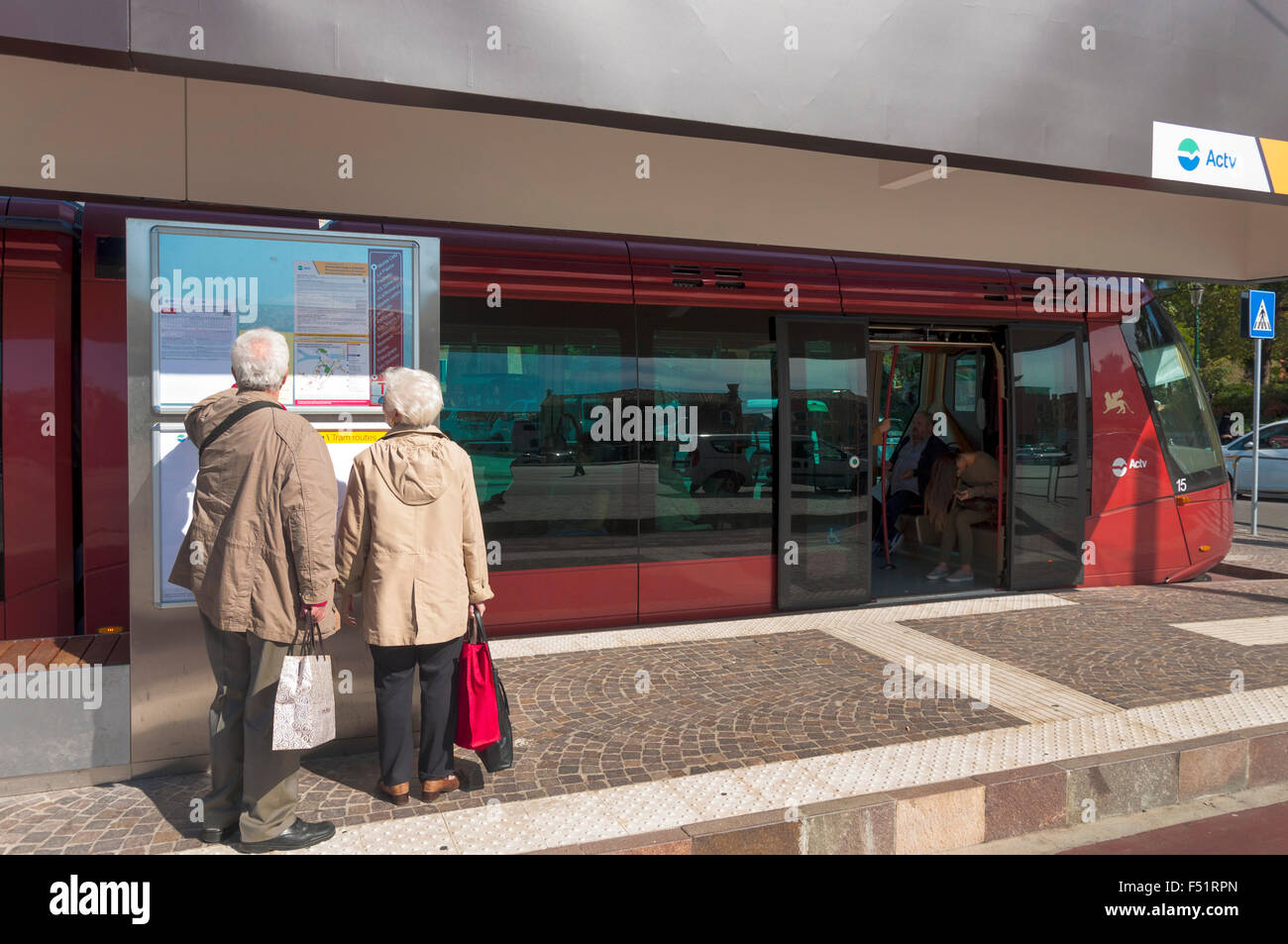 Elderly senior couple consult timetable for Actv tram in piazzale Roma, Venice, Italy Stock Photo