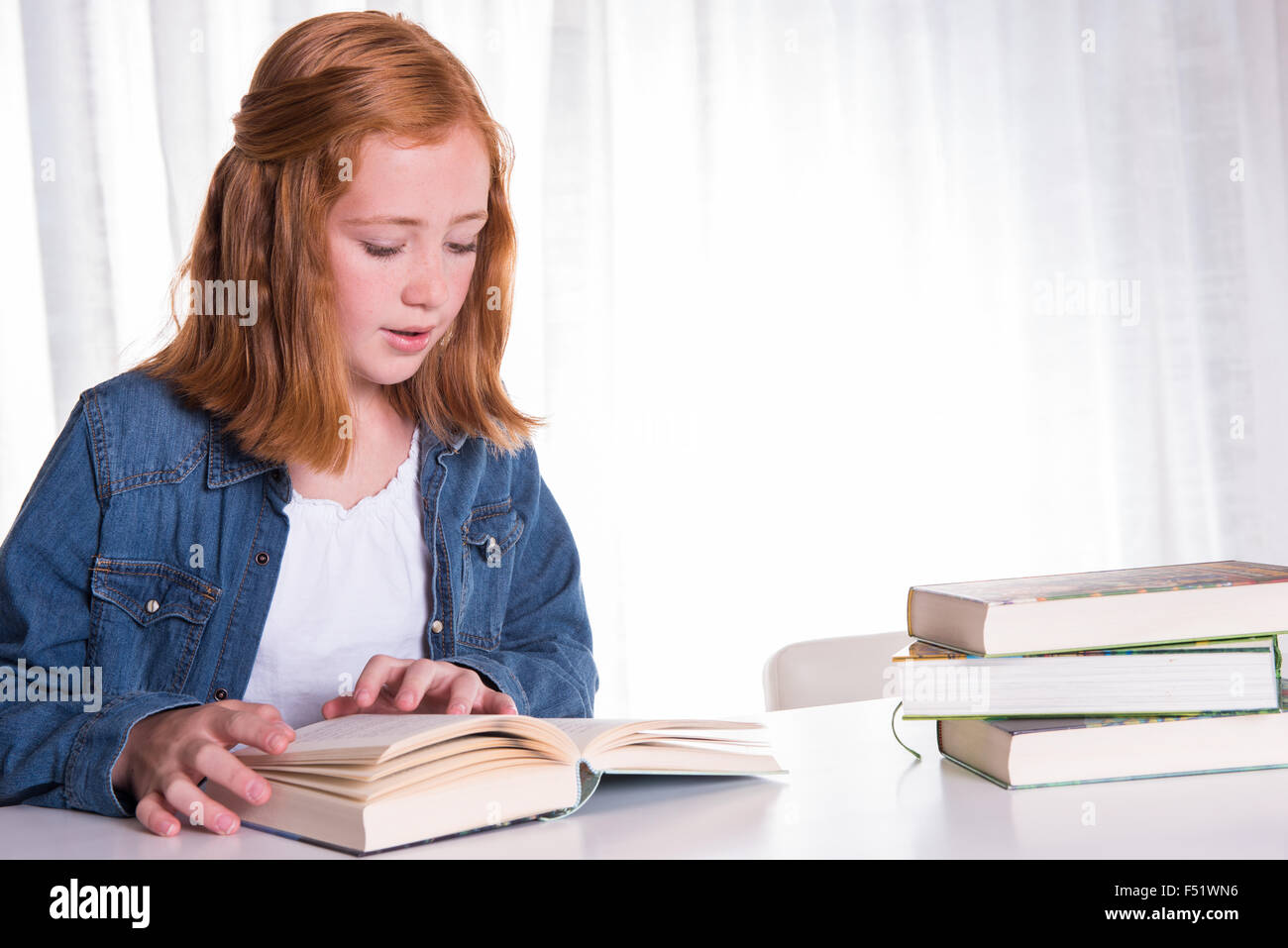 young redhead girl reading in books Stock Photo Alamy