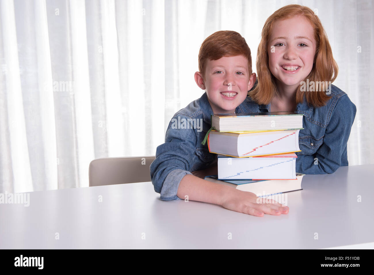 two kids and a pile of books Stock Photo