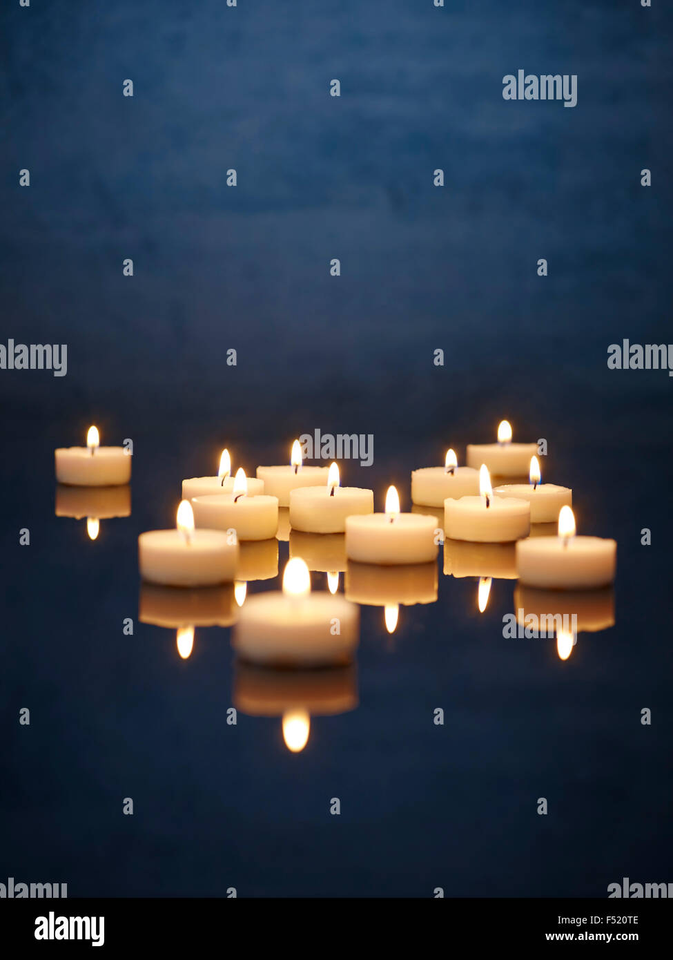Kerzen mit Spiegelung angezündet auf einem Tisch Stock Photo