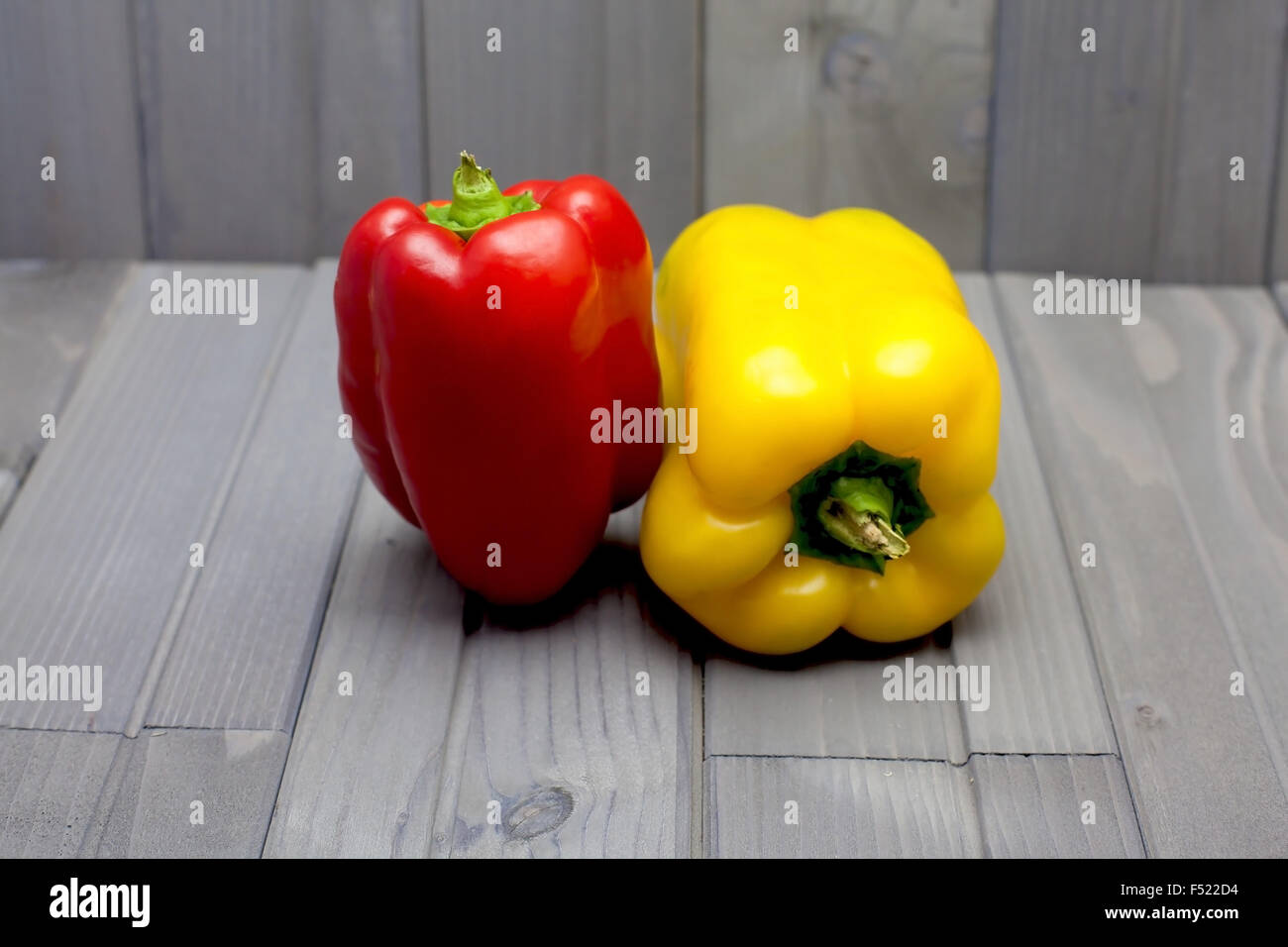 Red and yellow pepper on a gray wood table Stock Photo - Alamy