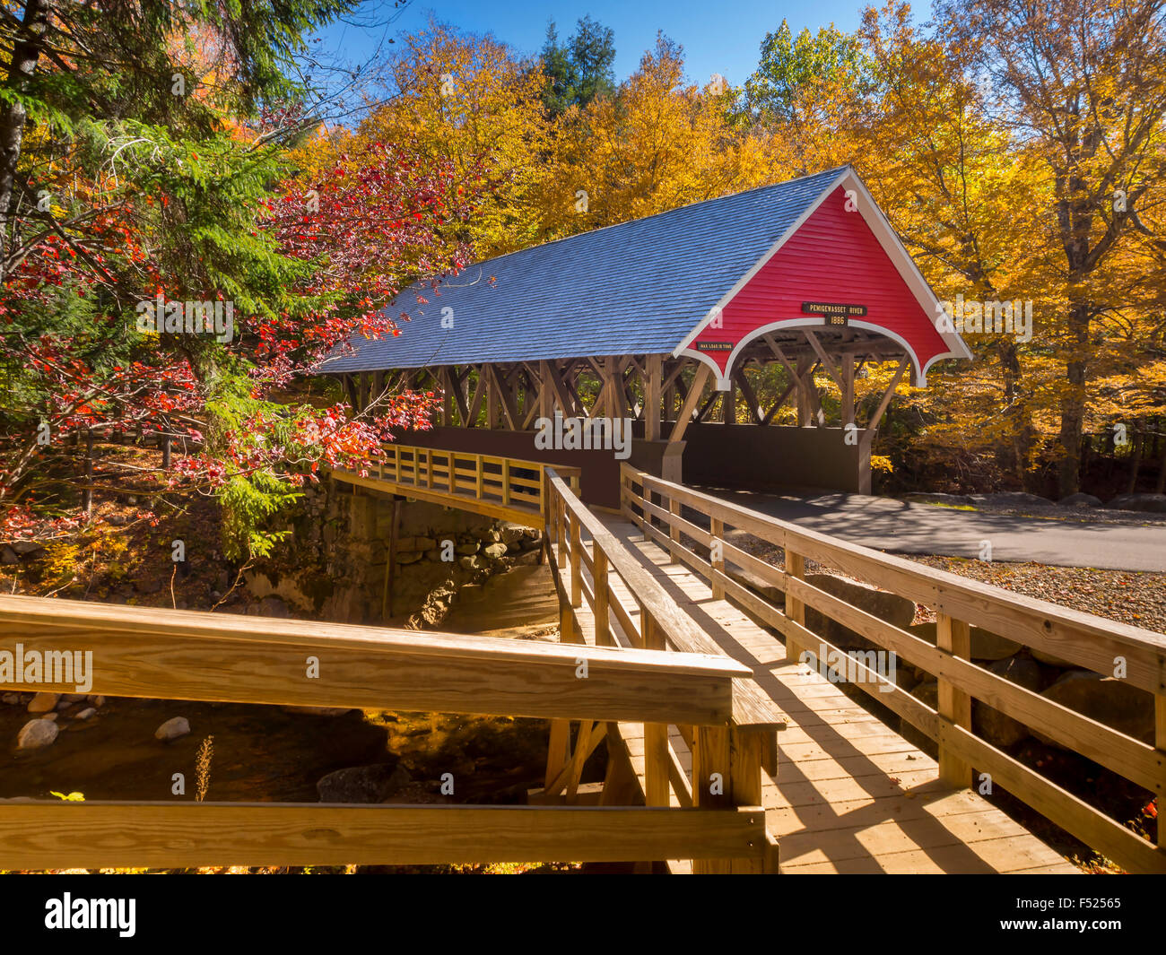 Red covered bridge in Fanconia New Hampshire during Fall season Stock Photo