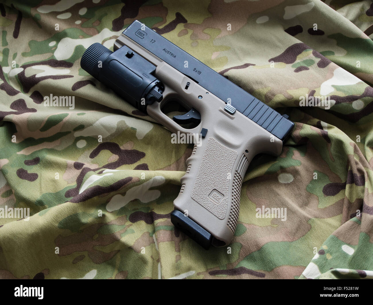 Glock 17 semi-automatic 9x19mm pistol and a Multicam pattern background  Stock Photo - Alamy