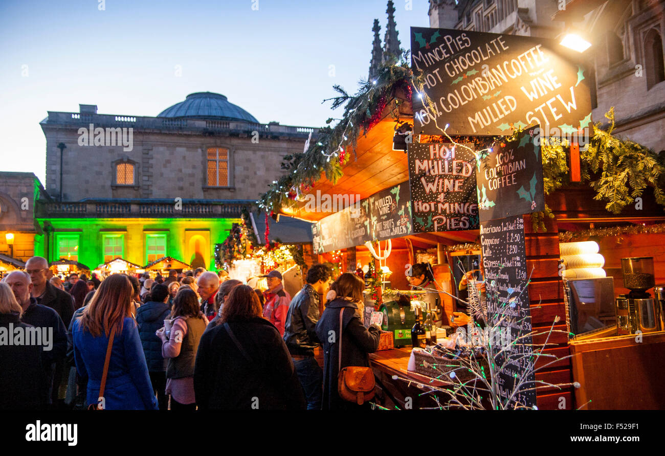 Christmas Market Bath with Roman Baths and Bath Abbey in background people at mulled wine stall Bath Somerset England UK Stock Photo