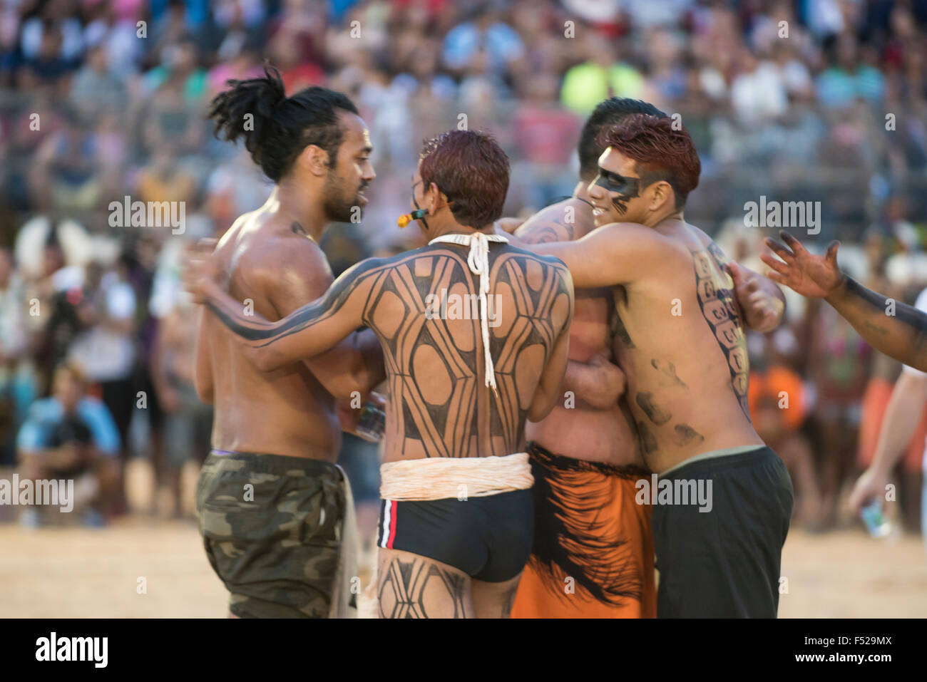 Palmas, Tocantins State, Brazil. 25th October, 2015. Kuikuro and Maori contestants congratulate each other and embrace in friendship after a tug of war at the International Indigenous Games, in the city of Palmas, Tocantins State, Brazil. The Brazilian Kuikuro won the bout. Credit:  Sue Cunningham Photographic/Alamy Live News Stock Photo
