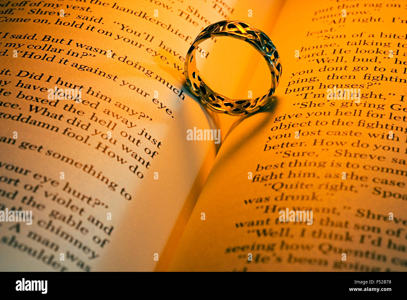 Ring lying on an open book with heart-shaped shadow Stock Photo