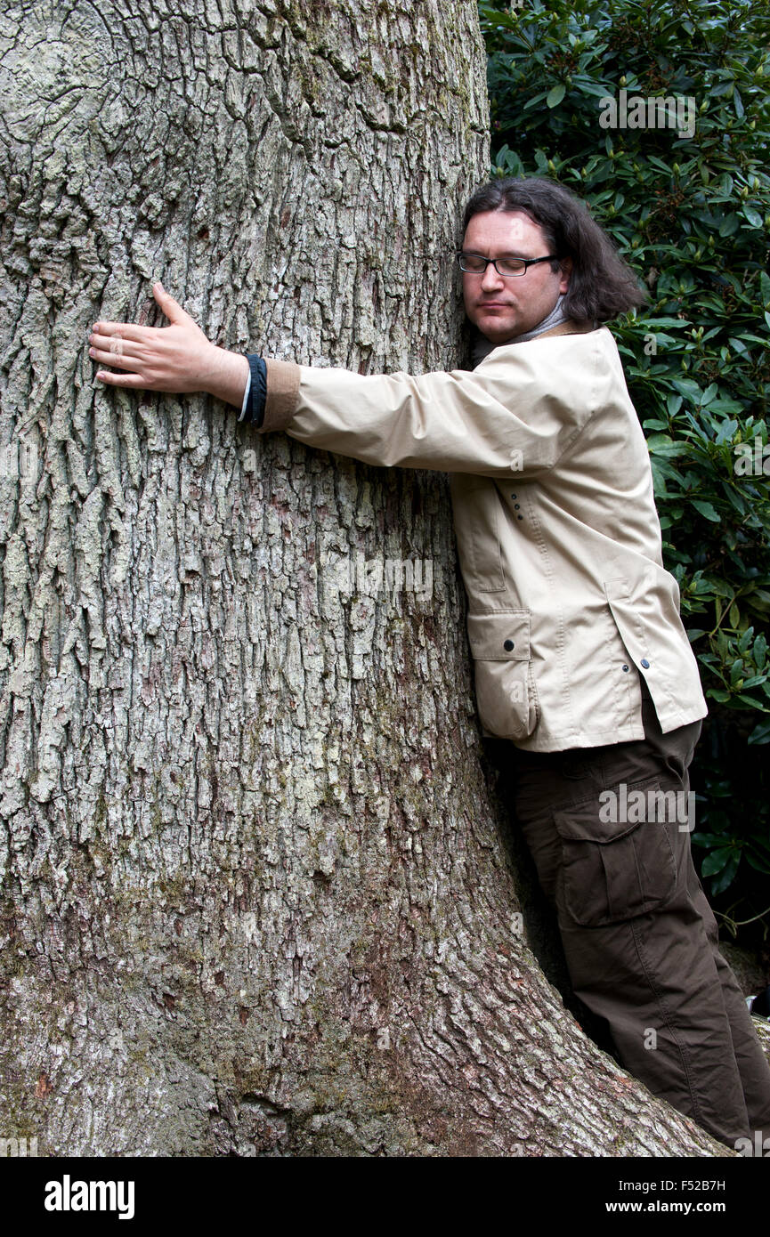 Man gives a huge tree a hug Stock Photo