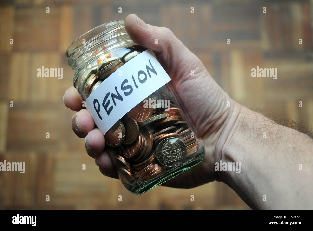 PENSION JAR WITH MONEY IN MANS HAND RE PRIVATE PENSIONS COMPANY INCOMES RETIREMENT SAVINGS WAGES STATE OLD AGE PENSIONERS UK Stock Photo