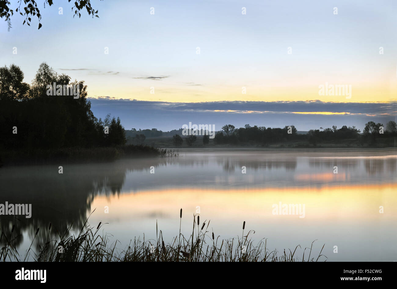 Sunrise landscape with a lake and the mist over the water Stock Photo ...