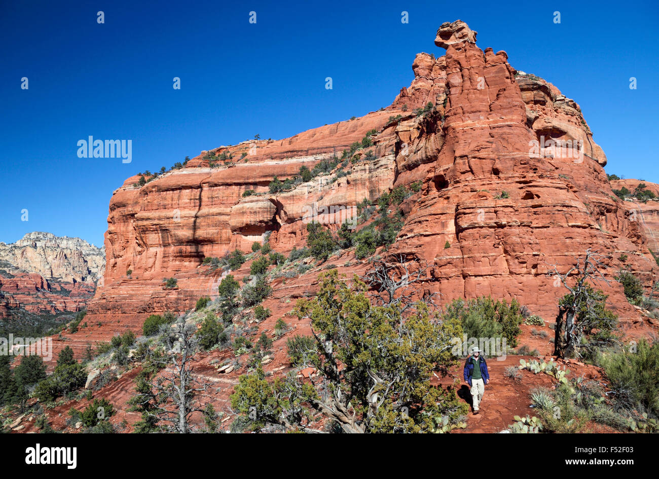 Hiker below Kachina Woman in Sedona, with  Boynton Canyon in distance Stock Photo