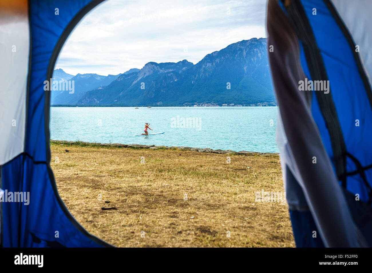 Looking through the tent to the paddleboarder. Lake Geneva, Switzerland. Stock Photo