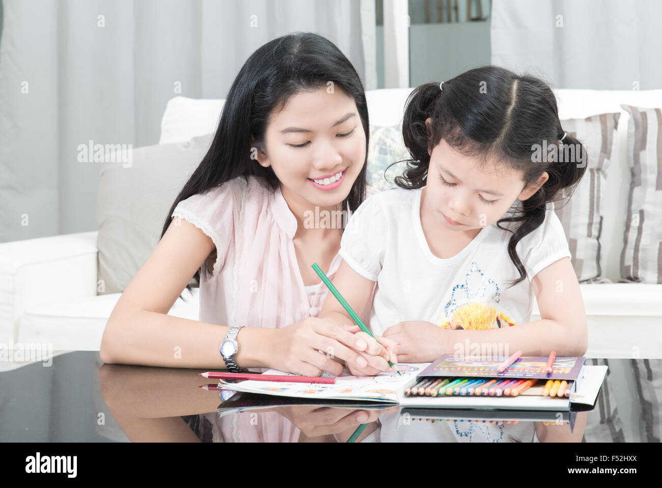 family, children and happy people concept - mother and daughter drawing at home Stock Photo