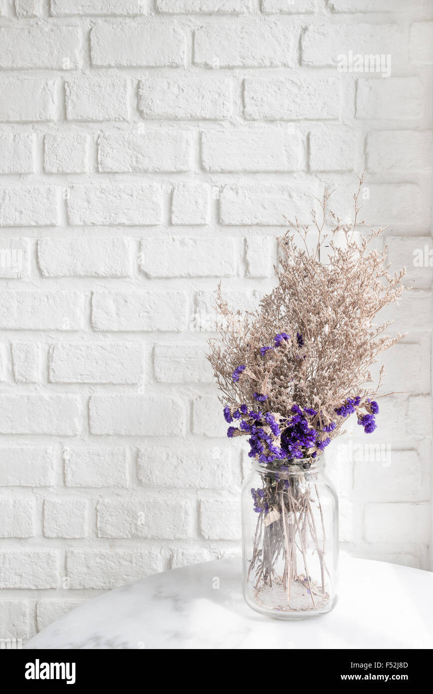 Composition of dried flowers on white wall brick in background Stock ...