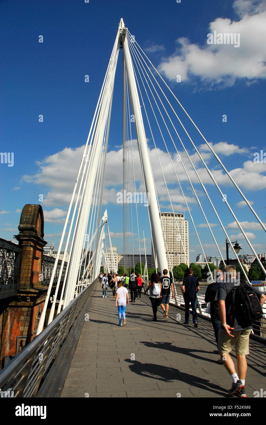 Pedestrians walking on the Hungerford Bridge over the River Thames next to the London Eye in London, England, UK Stock Photo