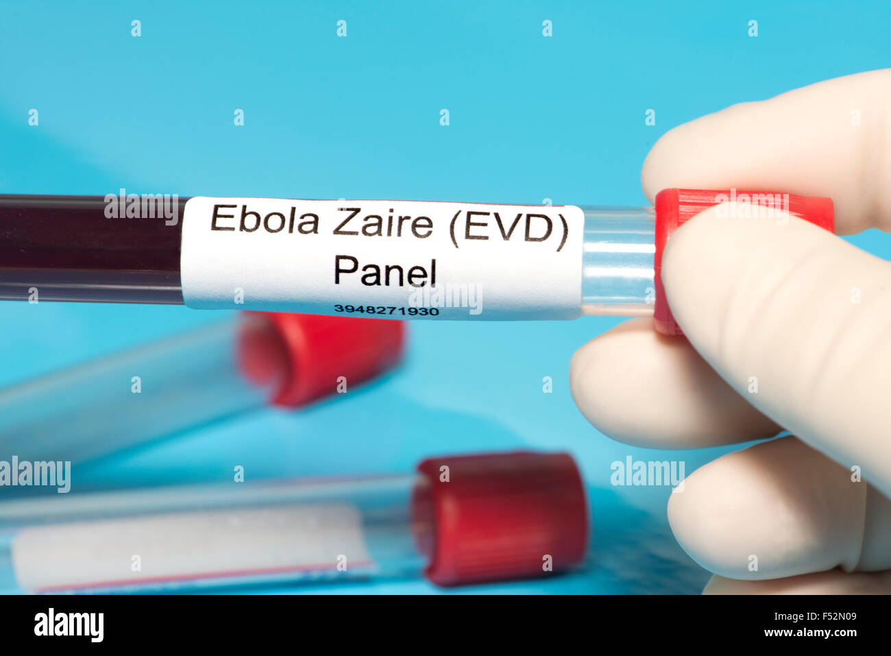 Technician holds Ebola Zaire blood test panel lab sample. Label is fictitious. Stock Photo