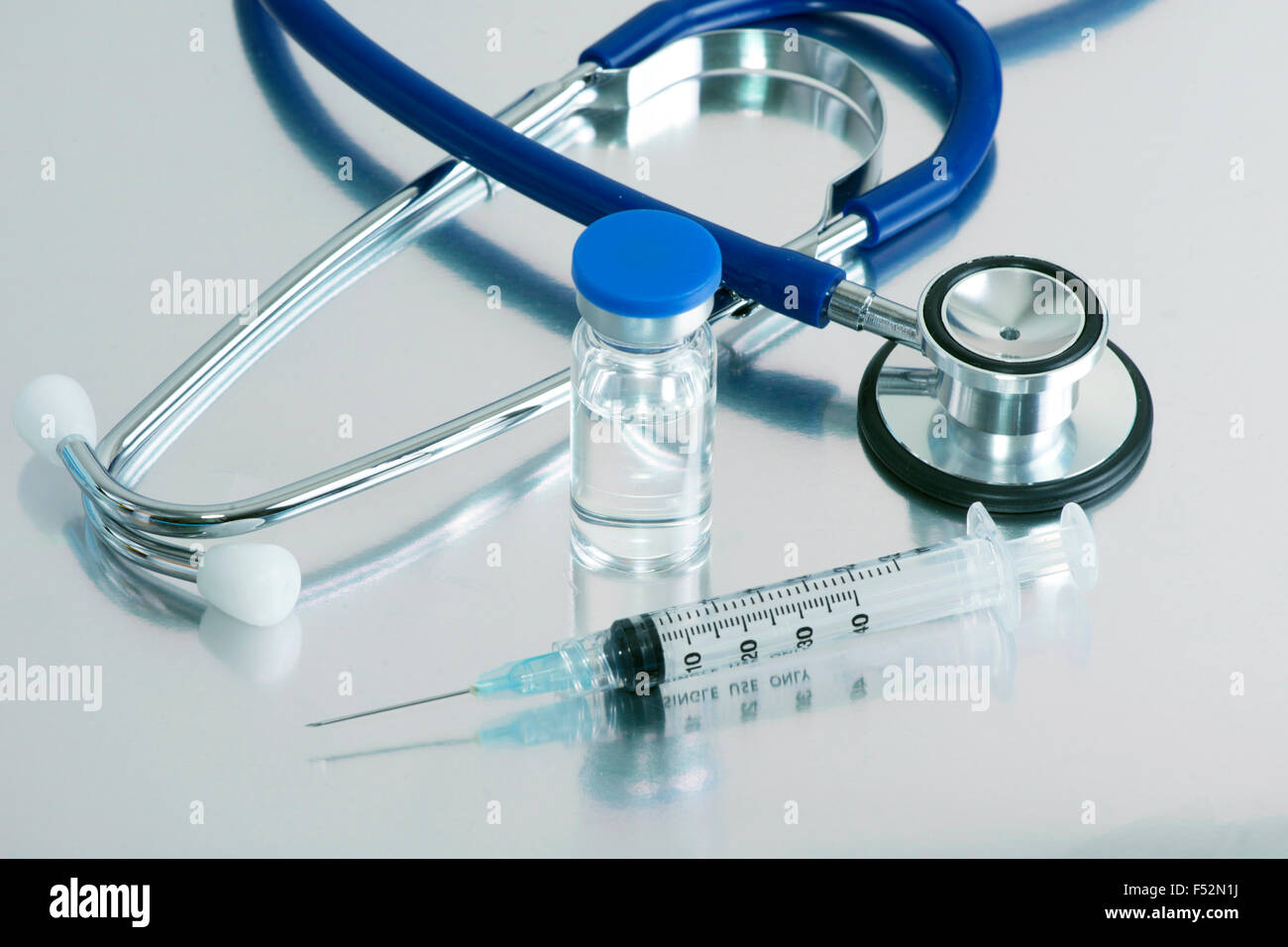 Syringe, vial and stethoscope on surgical tray. Stock Photo