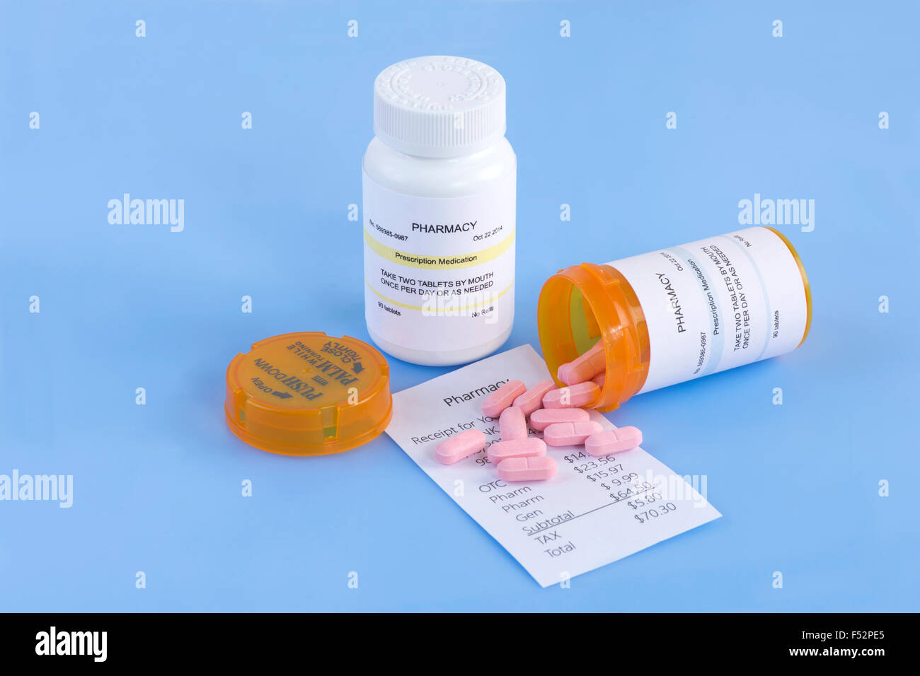 Prescription bottles, pills and pharmacy receipt on blue  background. Stock Photo